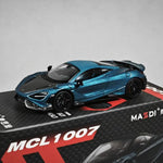 A metallic blue and black die-cast model of a McLaren sports car displayed on top of its black and red retail box. The box features the text 'MCL 1007' and 'MASSDI'.