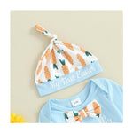 Baby hat and onesie set with carrot pattern and 'My First Easter' text on a beige background
