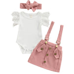 Baby outfit set with white onesie, pink Suspender Skirt, and matching headband on a white background
