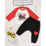 Children's outfit with red and white shirt and black pants on a light gray background