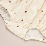 Close-up of a white baby diaper with embroidered designs on a beige background