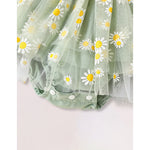 Green tulle fabric with white daisy flowers on a light pink background