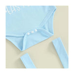 Light blue baby outfit with buttons on a beige background