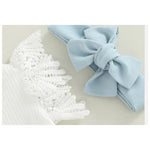 Light blue bow headband and white lace headband on a light background