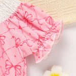 Pink baby bloomers with bow pattern on a light background
