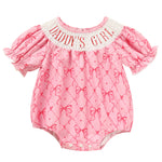 Pink baby romper with bow pattern and 'Daddy's Girl' text on a white background