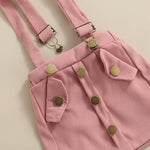 Pink denim overalls with suspenders on a beige background