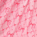 Pink fabric with red bow and heart pattern