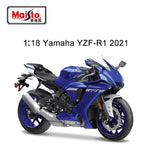 A blue and white Yamaha YZF-R1 sport motorcycle shown on a clean white background, with text reading '1:18 Yamaha YZF-R1 2021' and a Maisto logo in the top left corner.
